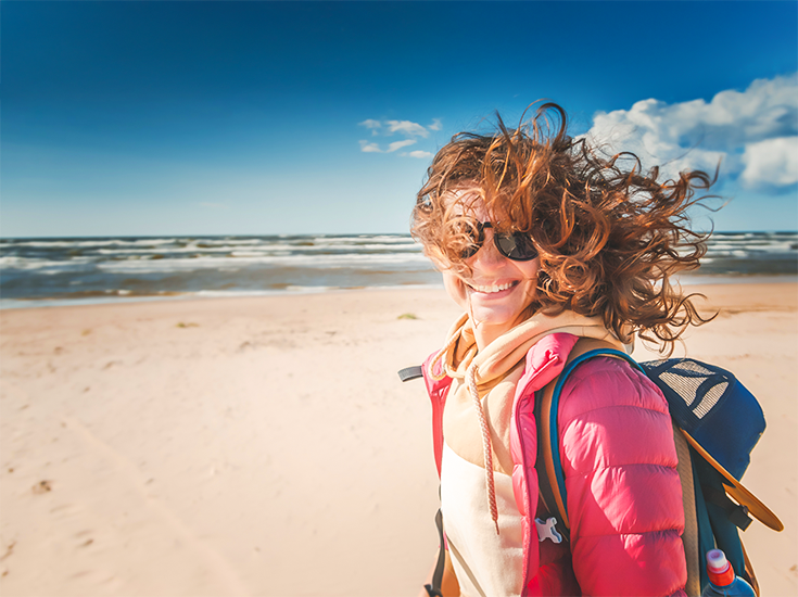 Mitgliedschaft: Bild einer glücklichen Frau am Strand